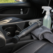 Noviquieo DetailSpin Interior Cleaning Brush beside a car console